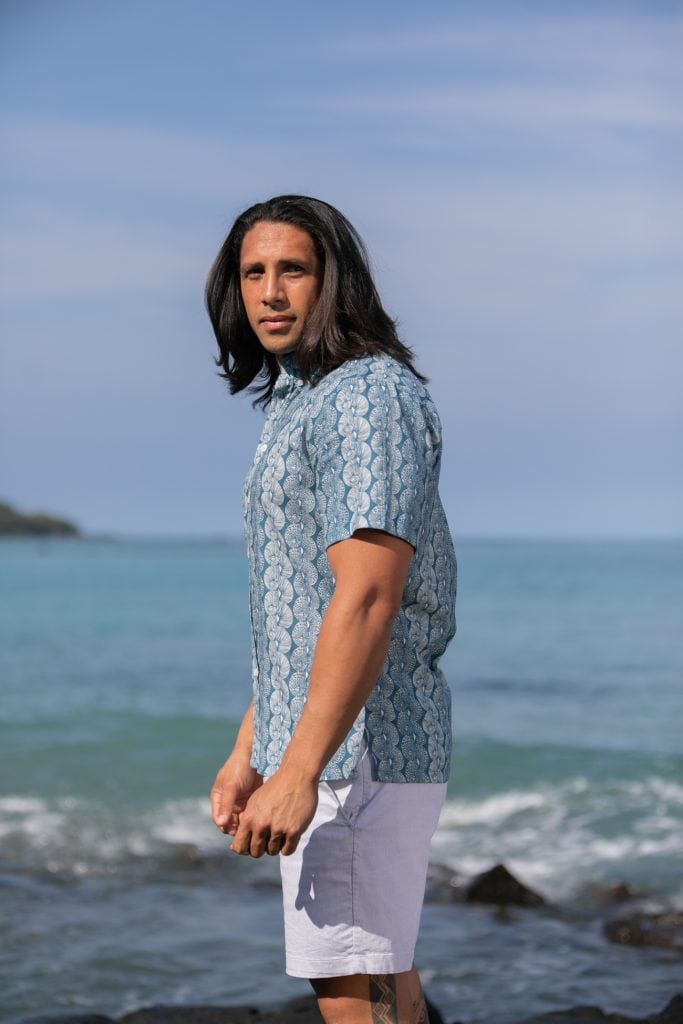 Male model wearing Aloha Short Sleeve in a Lei Kupee Print and Real Teal/Tofu Color - Side View