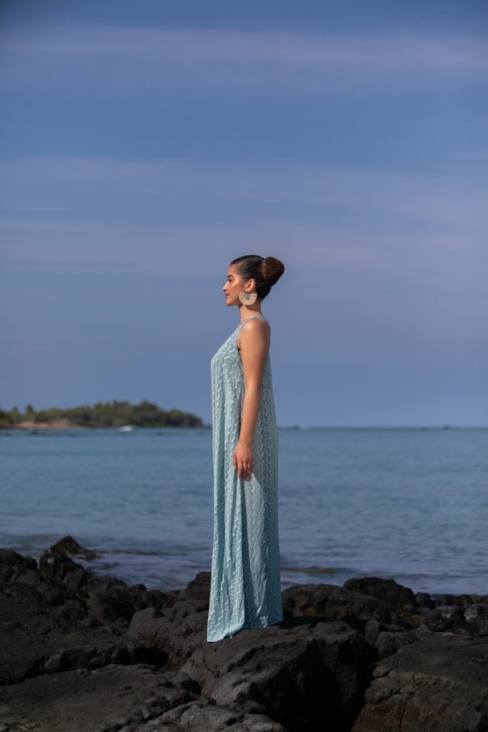 Female model wearing Kaimanahila Long Dress in a Lei Kupee Print and Blue Tint/Real Teal Color - Side View