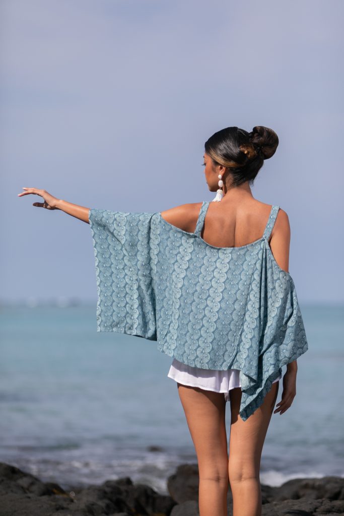 Female model wearing a Konane in Lei Kupee Print and Real Teal/Blue Tint Color - Back View