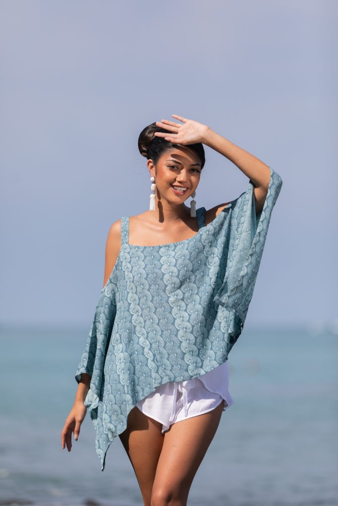 Female model wearing a Konane in Lei Kupee Print and Real Teal/Blue Tint Color - Front View