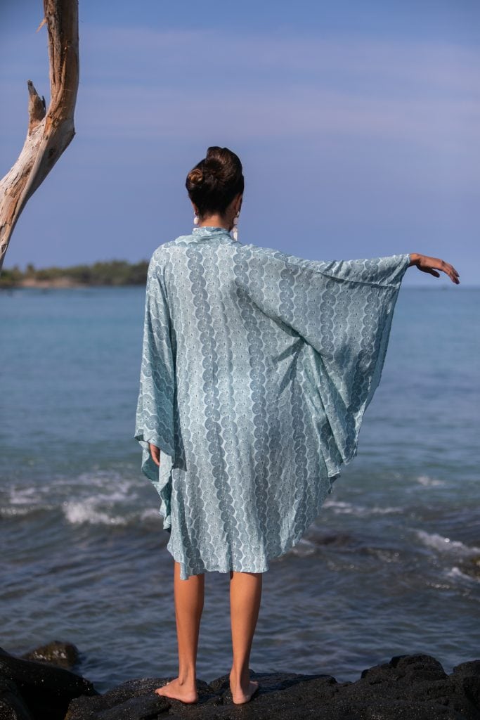 Female model wearing a Olapa Kaftan in Lei Kupee Print and Real Teal/Blue Tint Color - Back View