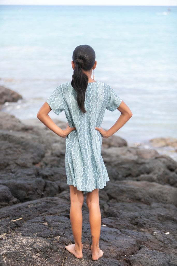 Girl model wearing Opio Romper in a Lei Kupee Print and Real Teal/Blue Tint Color - Back View