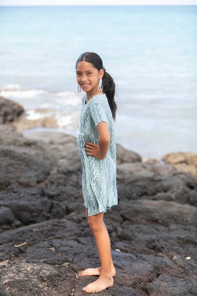 Girl model wearing Opio Romper in a Lei Kupee Print and Real Teal/Blue Tint Color - Side View