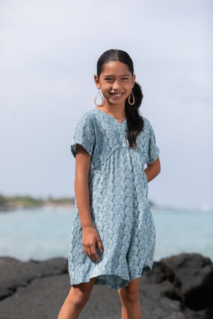 Girl model wearing Opio Romper in a Lei Kupee Print and Real Teal/Blue Tint Color - Front View