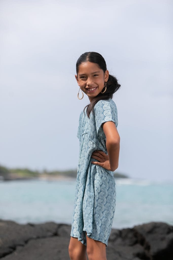 Girl model wearing Opio Romper in a Lei Kupee Print and Real Teal/Blue Tint Color - Side View