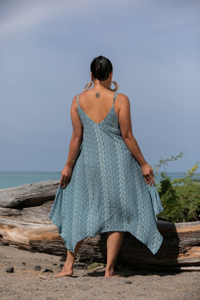 Female model wearing a Pualahilahi Dress in Lei Kupee Print and Real Teal/Blue Tint Color - Back View